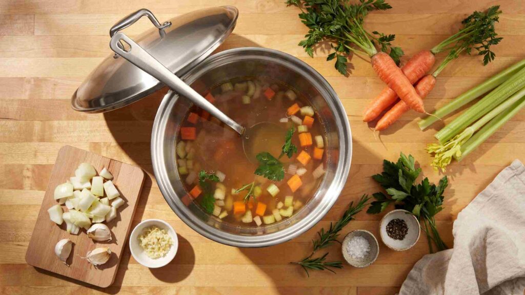 Stainless steel stock pot filled with vegetables for everyday cooking.